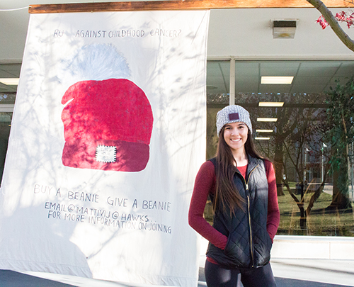 Julia Mattivi stands in front of a Love Your Melon banner. 