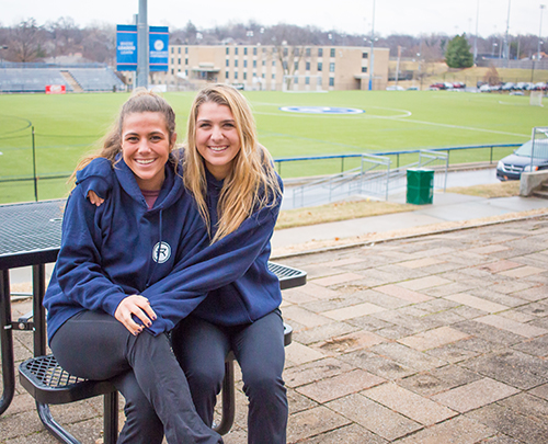 Angela and Lauren Merlo sit near the Rockhurst soccer field.