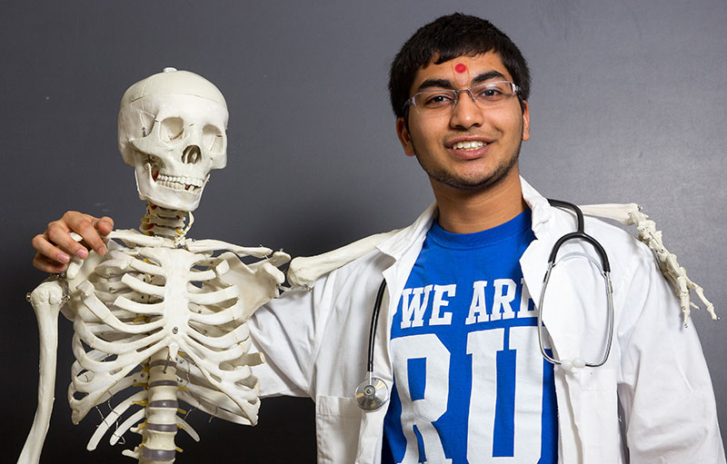 Pre-Med student posing with skeleton