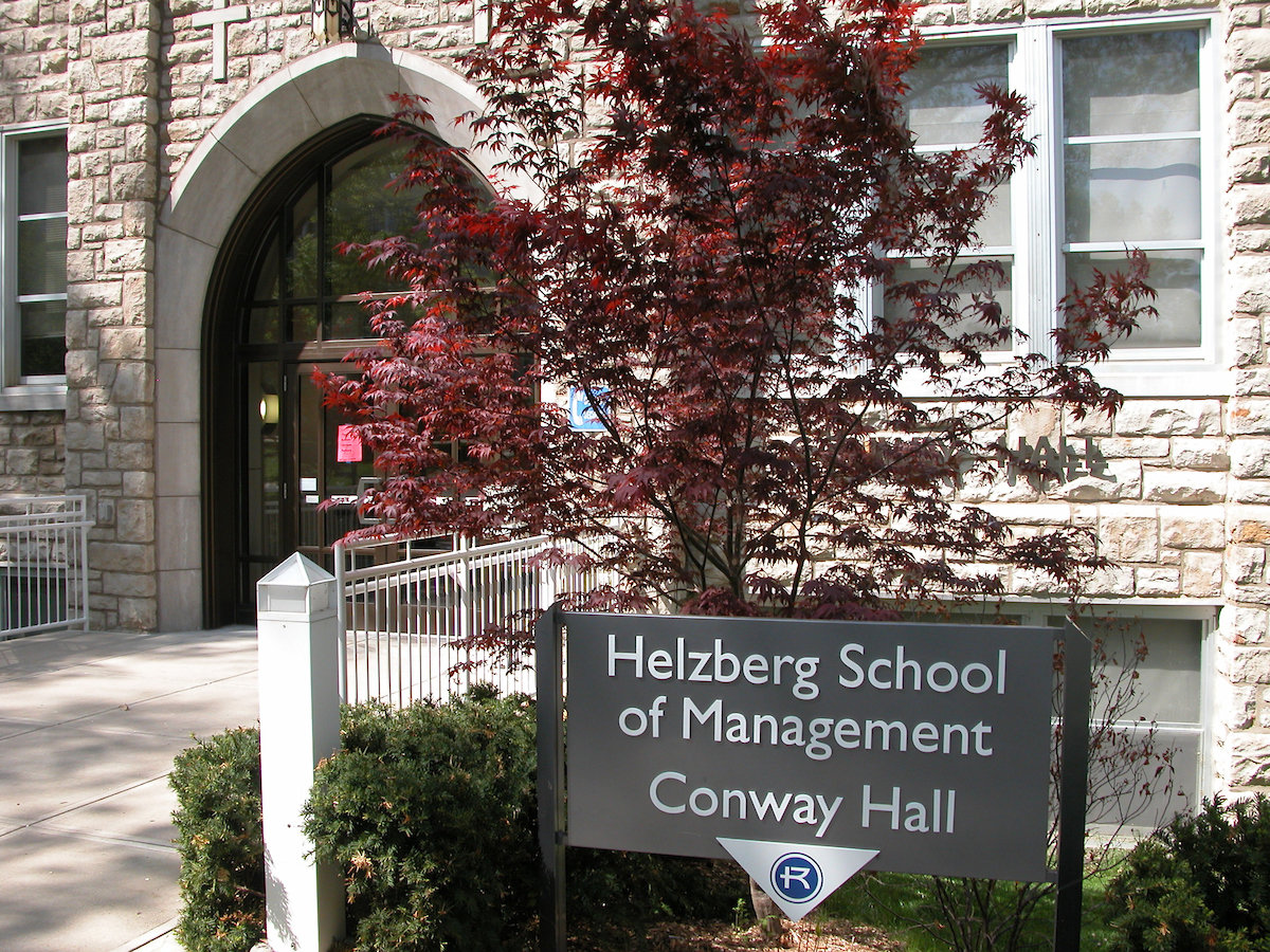 Helzberg School of Management sign with red leaves behind 