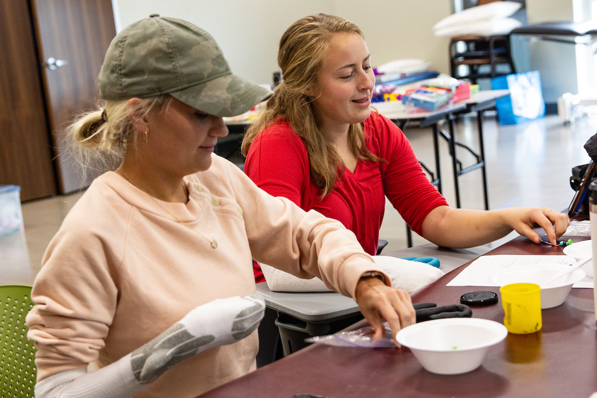 OT students perform a lab limiting the use of their arms