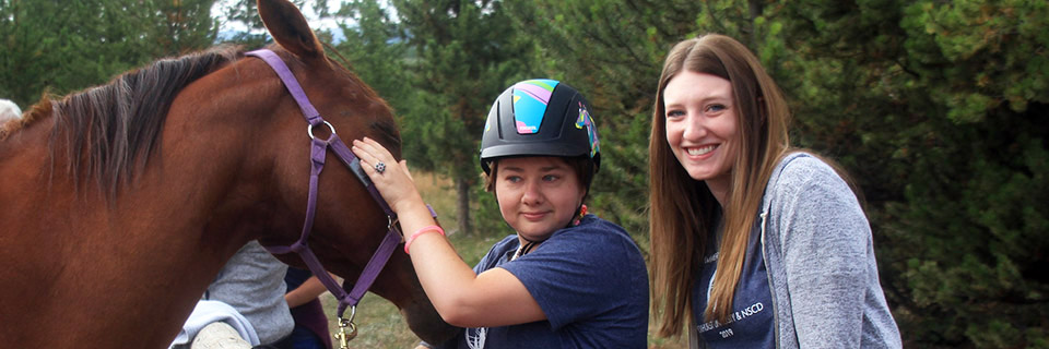 An OT student works with a child, doing animal therapy