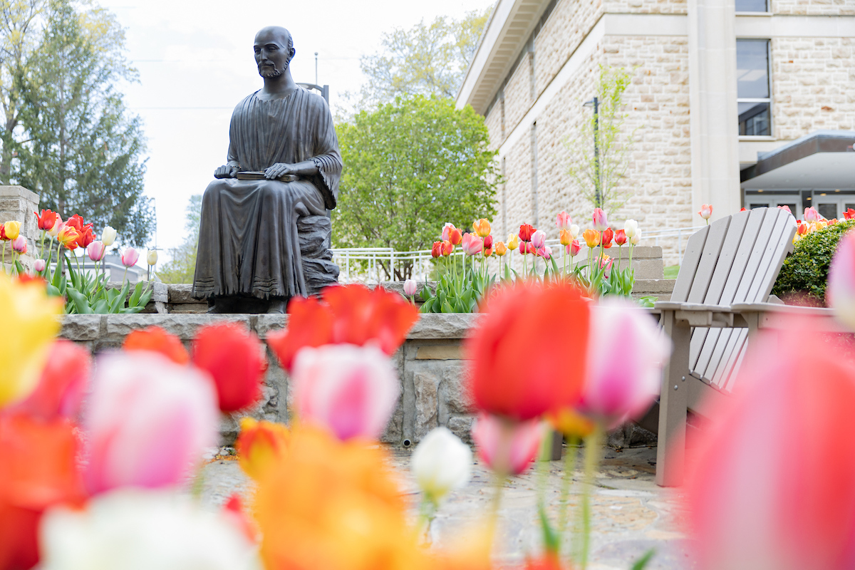 Saint Ignatius of Loyola statue with tulips in the foreground