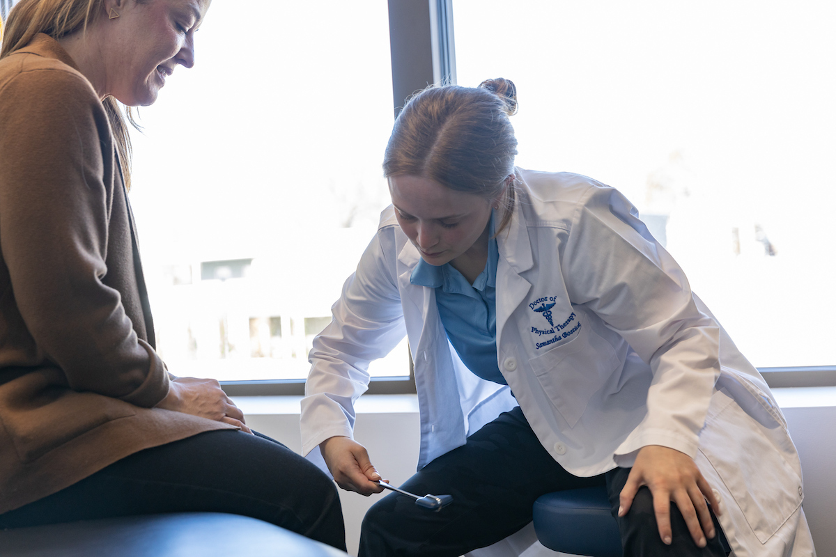 Female PT student works with faculty