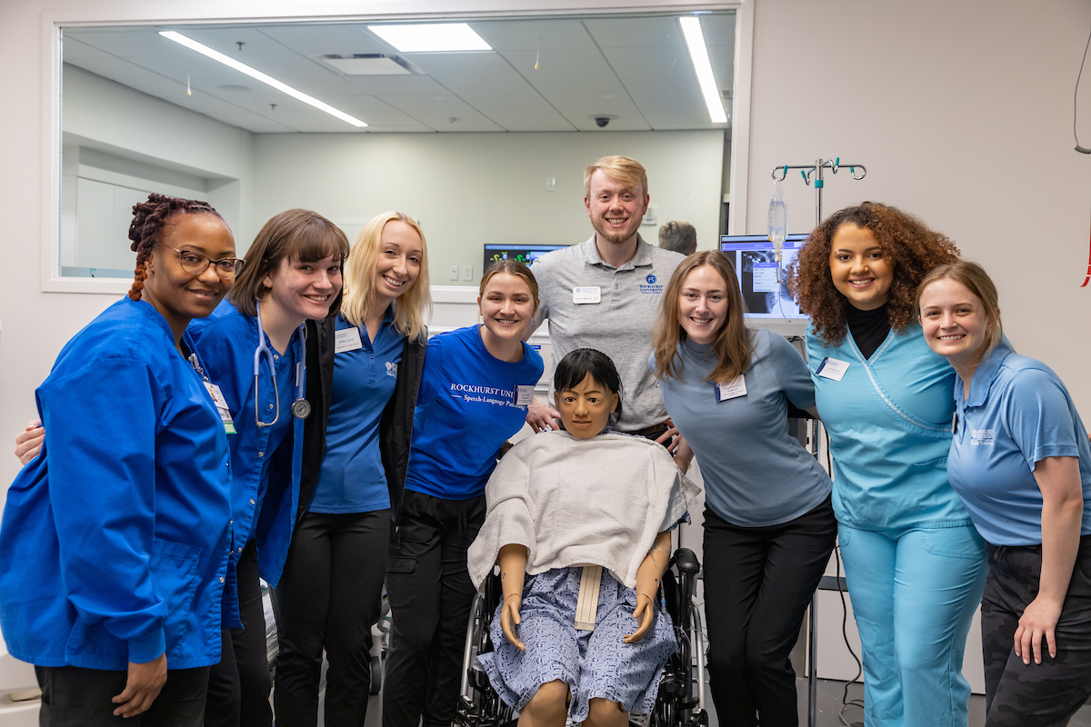 Students from nursing, csd, ot and pt pose in the simulation lab