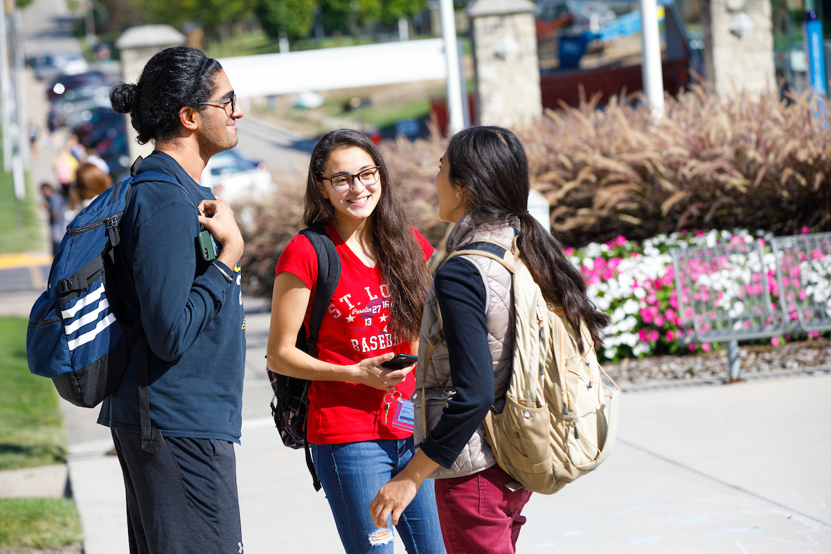 three students meet on campus to go to their Diversity, Equity and Inclusion classes.