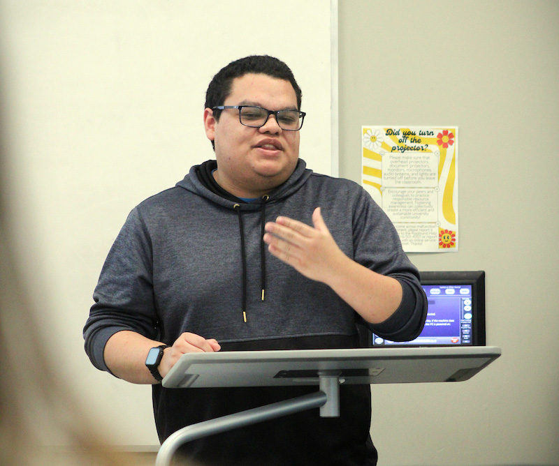 A male student gives a presentation to a class