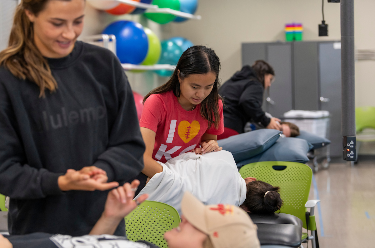 Female students practice physical therapy techniques on classmates as part of Rockhurst's DPT program