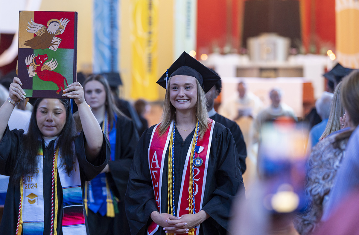 Two female students participate in mass 