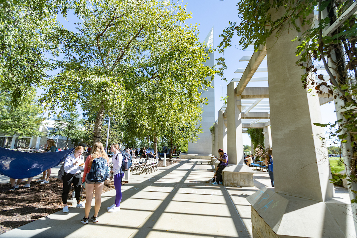 Students talk near the pergola on campus at Rockhurst University. The bell tower is in the background. 