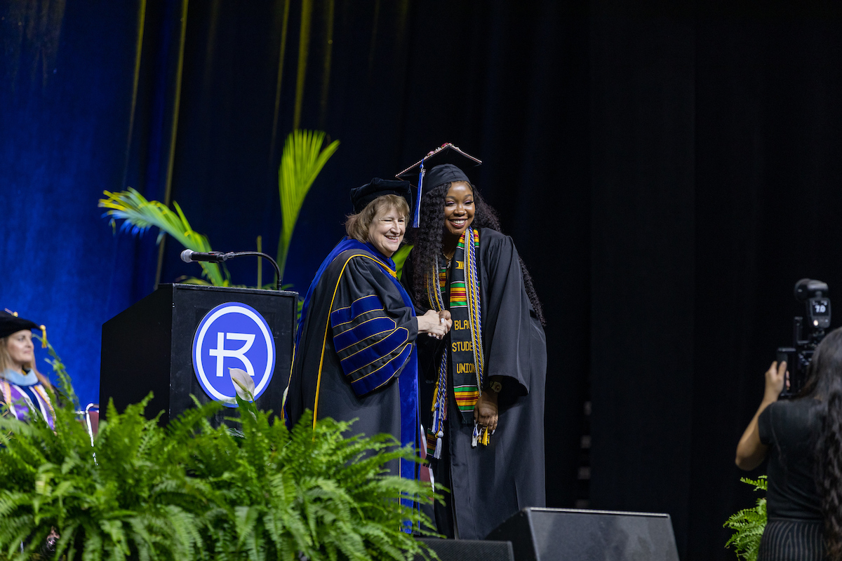 Dr. Cassady posing for a picture with a female graduate