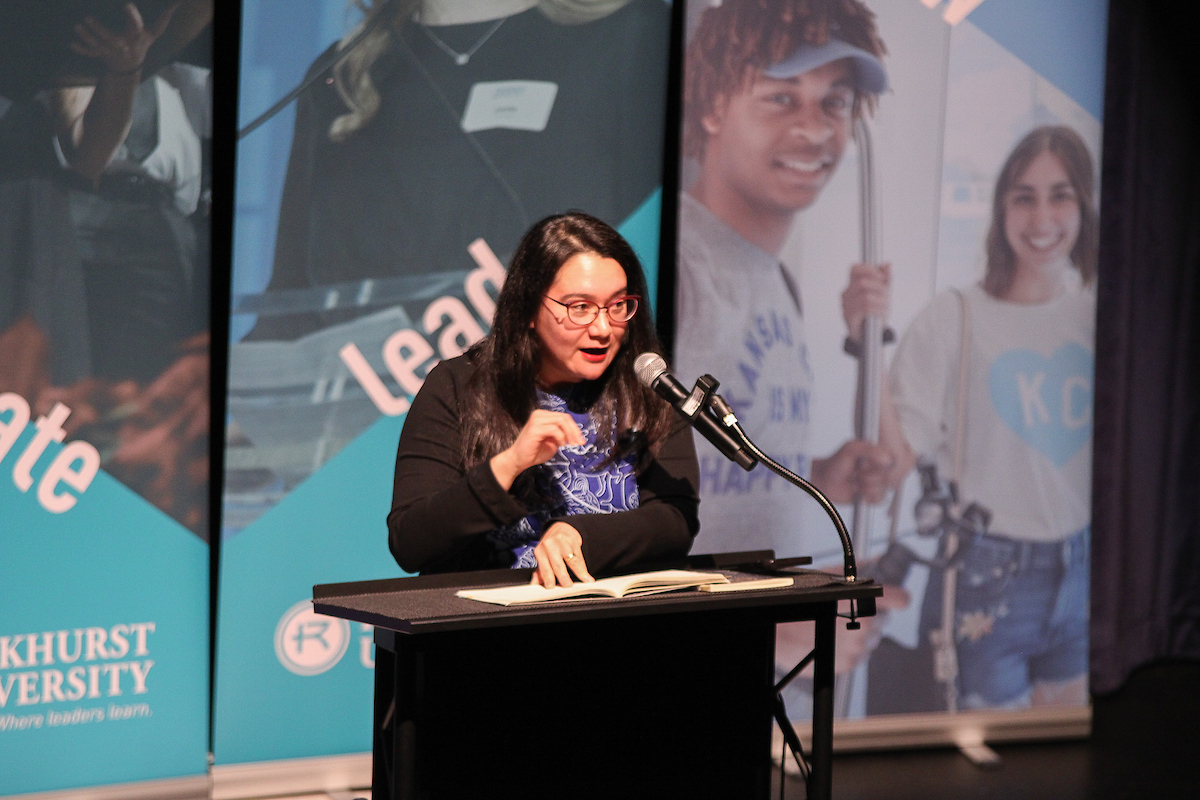 A poet reads from behind a podium