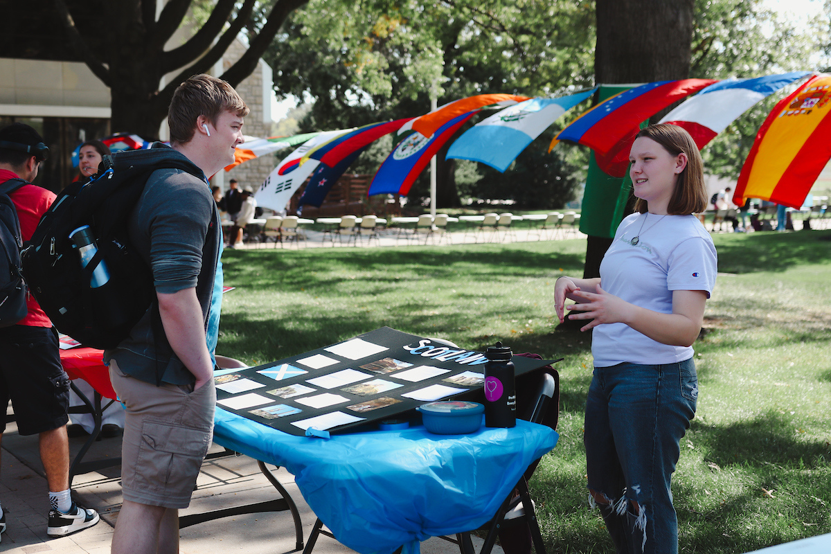 A girl talks to a student about her Scotland display at World Cultures Day