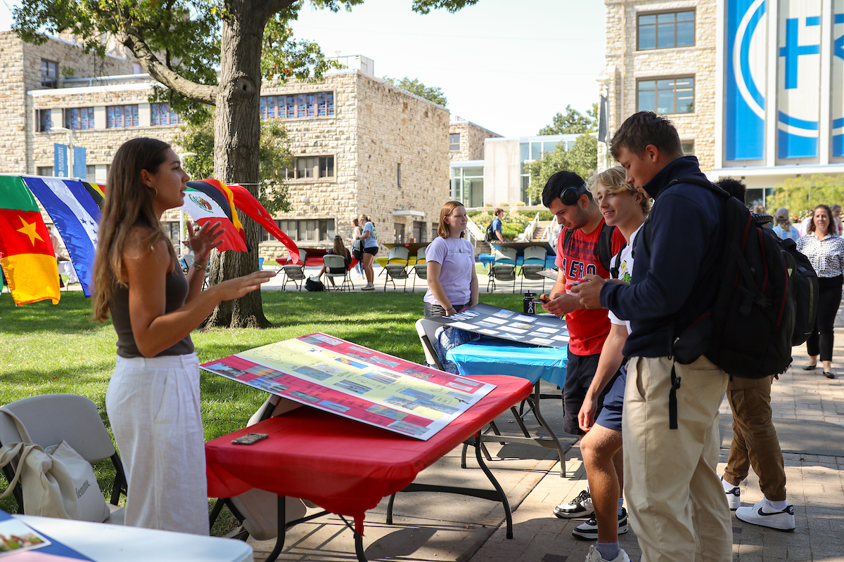 Students talk over a display at World Cultures Day 2024