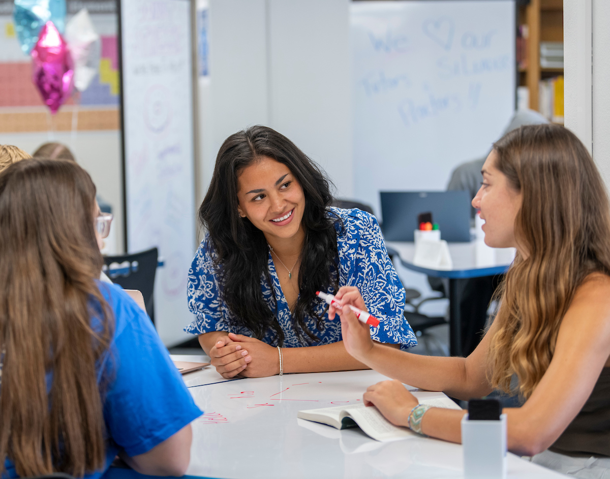 Students talk at a Learning Center table 