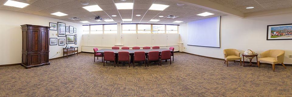 Regents Room - large table, armoir, framed photos, two chairs with side table. 