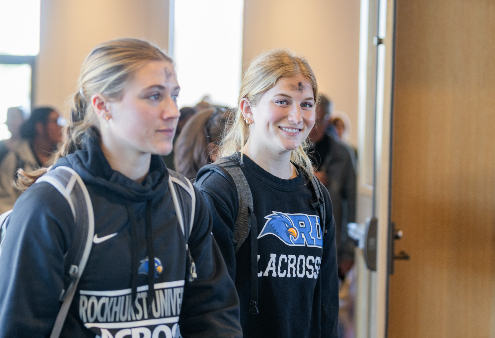 Two women's lacrosse player leave an Ash Wednesday service with ash on their foreheads