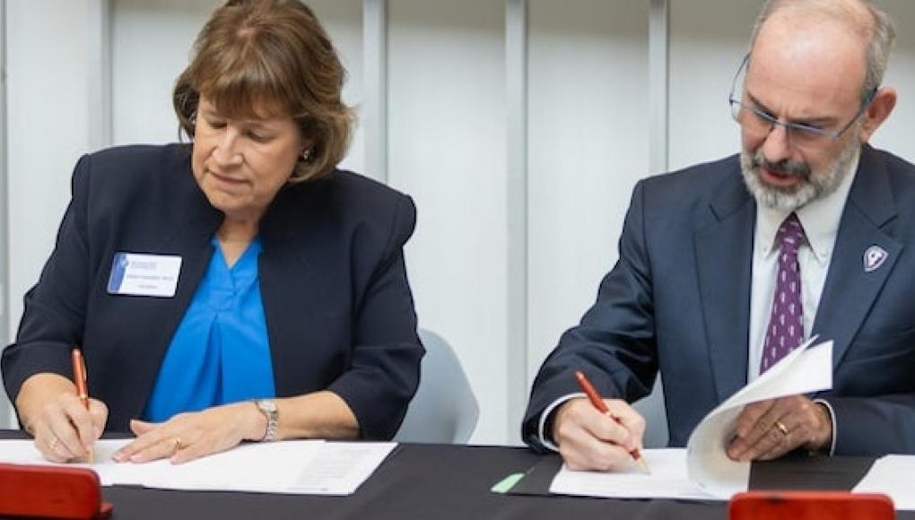 Rockhurst University and Kansas City University leaders signing a new agreement