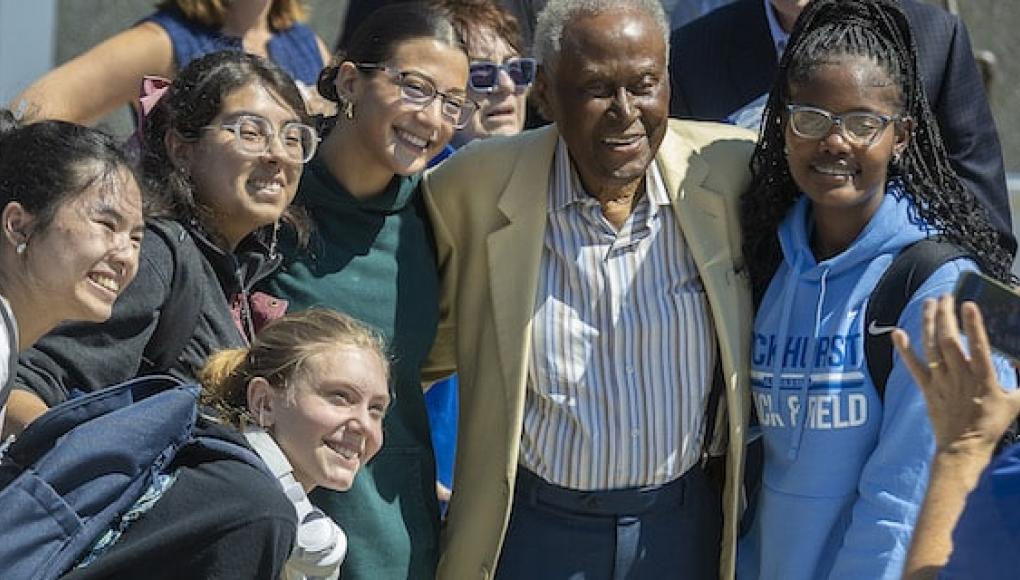 Students take a photo with Alvin Brooks during a beam topping ceremony