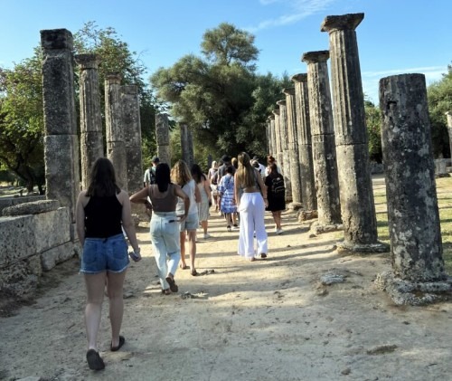 Students walk among ancient columns in Greece