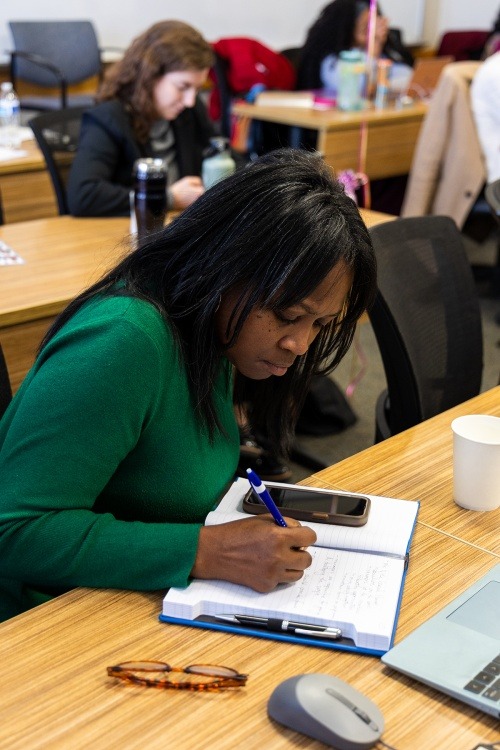 A graduate student writes in a notebook
