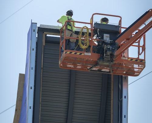 Workers place the final beam at the top of the new Mabee Chapel