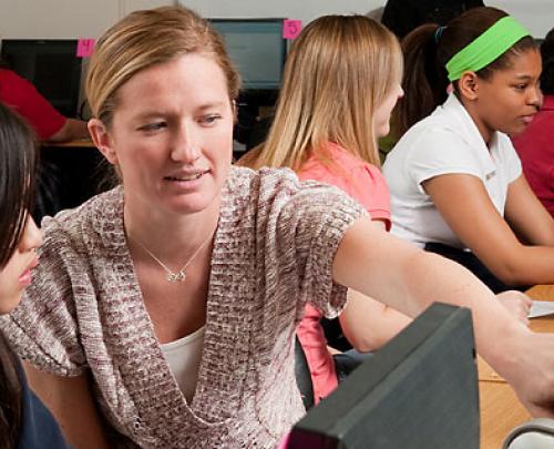 Female teacher in foreground with two female students in background