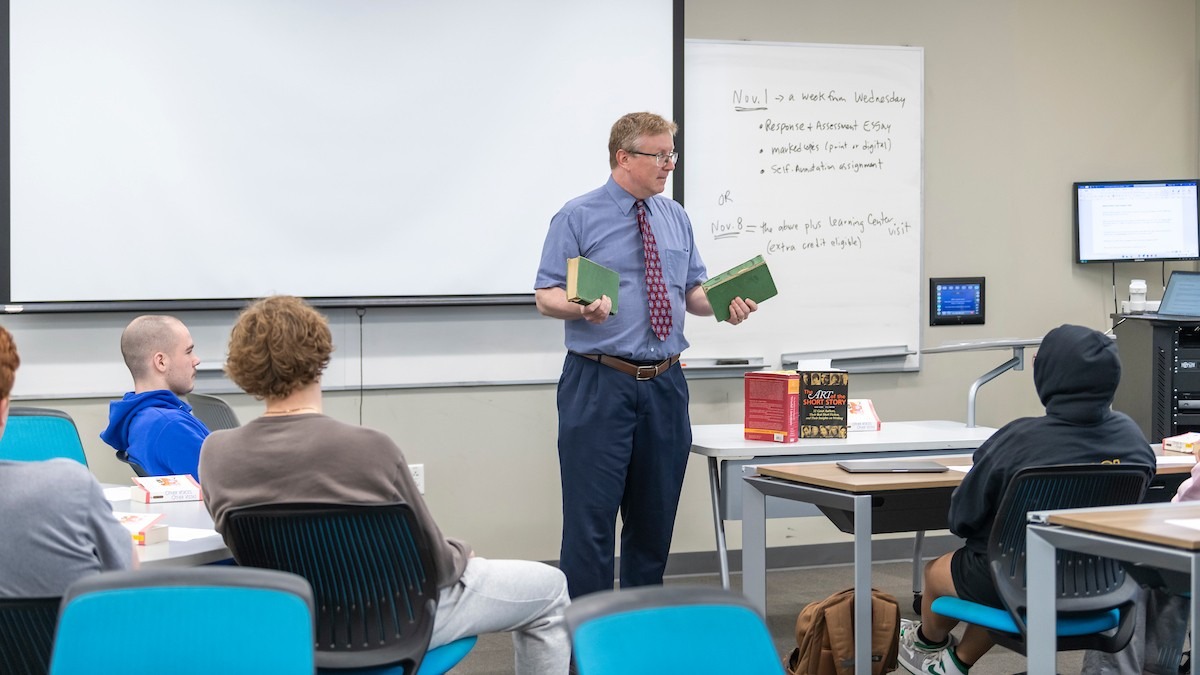A instructor stands in-front of a classroom full of Nonprofit Administration Certificate students giving a lecture.