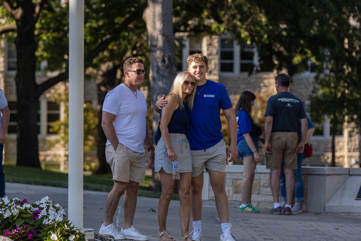 A freshman hugs his mom as his dad stands by 