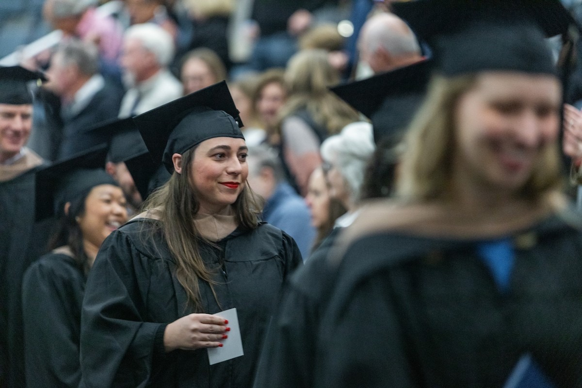 An MBA graduate walks in a procession at Commencement