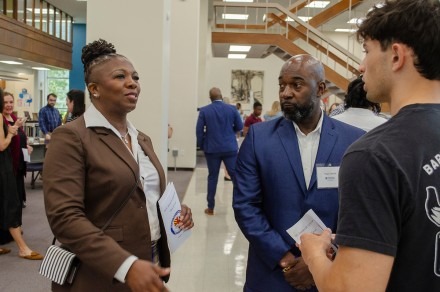 Two Ed.D. graduate students discuss a project with an undergraduate student.