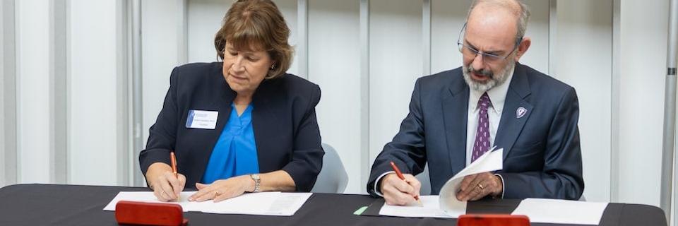 Rockhurst University and Kansas City University leaders signing a new agreement