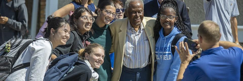 Students take a photo with Alvin Brooks during a beam topping ceremony