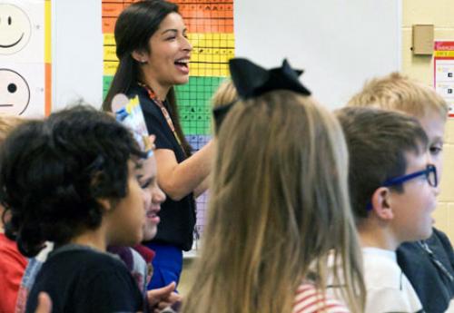 female teacher instructing a classroom of elementary school children