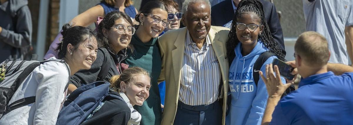 Students take a photo with Alvin Brooks during a beam topping ceremony